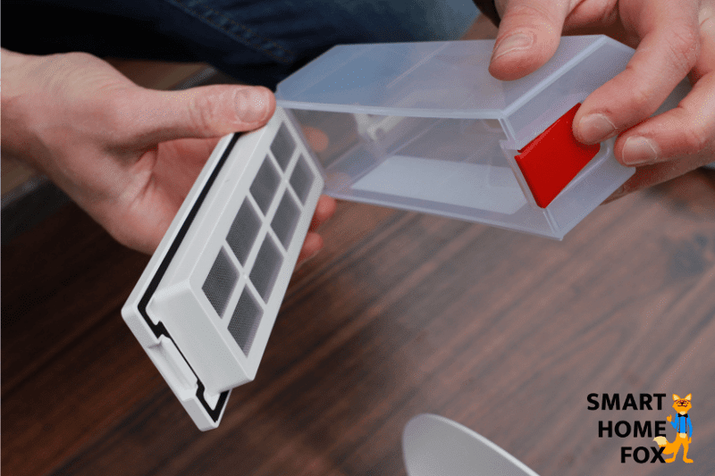 Staubbehälter des Ecovacs Deebot T9 wird durch das Drücken des roten Knopfes geöffnet.